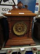 OAK MANTEL CLOCK WITH BRASS ARABIC CHAPTER RING AND CARVED DETAIL WITH STEPPED BASE