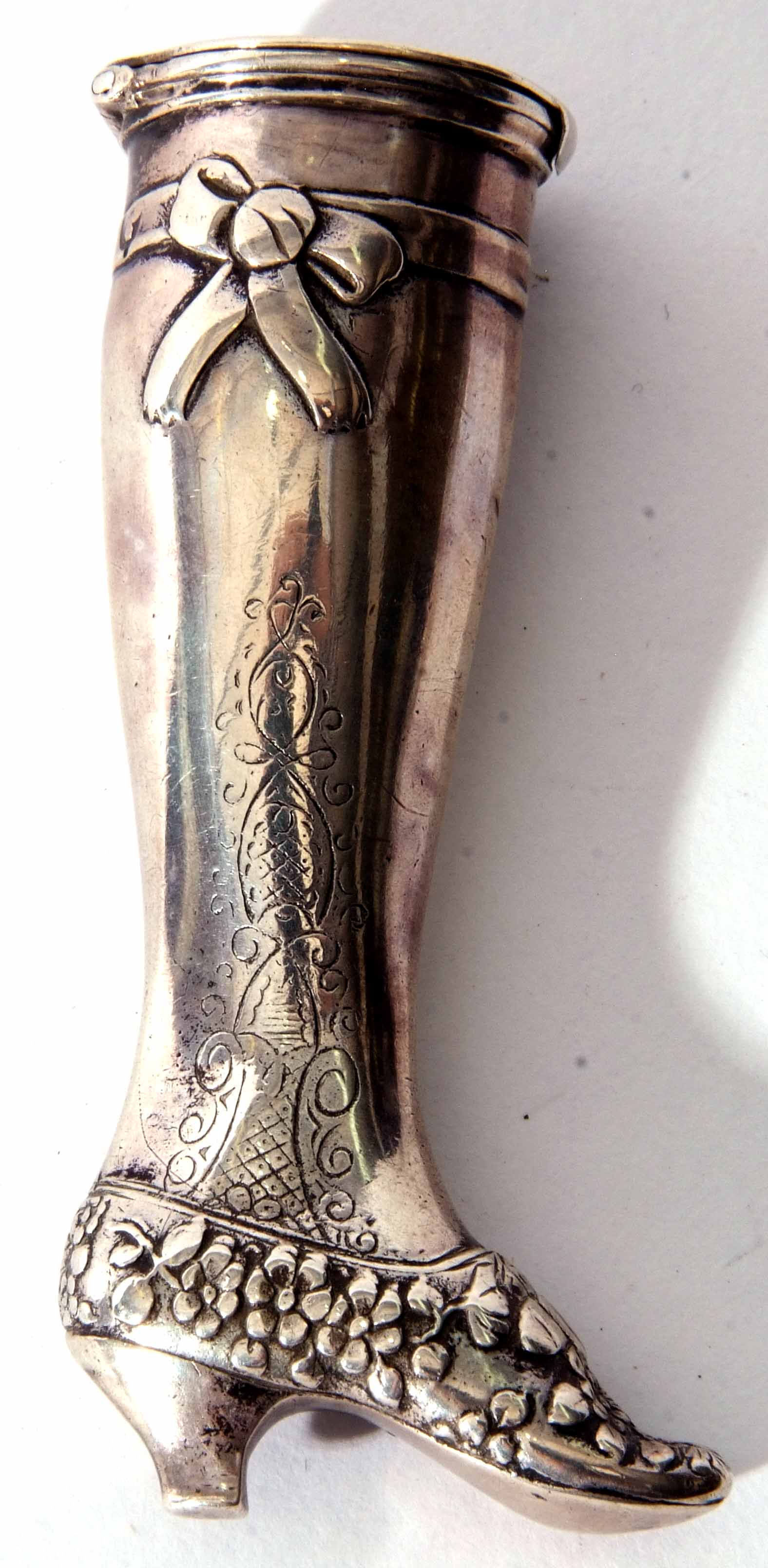 Continental white metal pill canister modelled in the form of a lady's right leg with floral