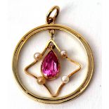 A 15c stamped open work pendant of circular form with an articulated pear shaped pink stone and