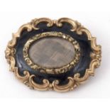 Victorian mourning brooch, the oval glazed centre with plaited hair panel, within a black enamel