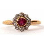 An 18ct ruby and diamond cluster ring, the circular cut faceted ruby bezel set in a surround of