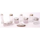 Mixed Lot: comprising four various silver lidded cylindrical toiletry jars, all with embossed