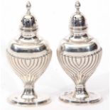Two late Victorian pepper casters, each of inverted oval baluster form with wrythen decoration on