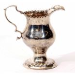 George III milk jug of baluster form with punched and shaped rim, cast and applied handle on