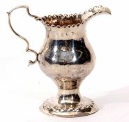 George III milk jug of baluster form with punched and shaped rim, cast and applied handle on