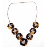 Faux tortoiseshell necklace featuring seven octagonal shaped plaques, each inlaid with palm trees,