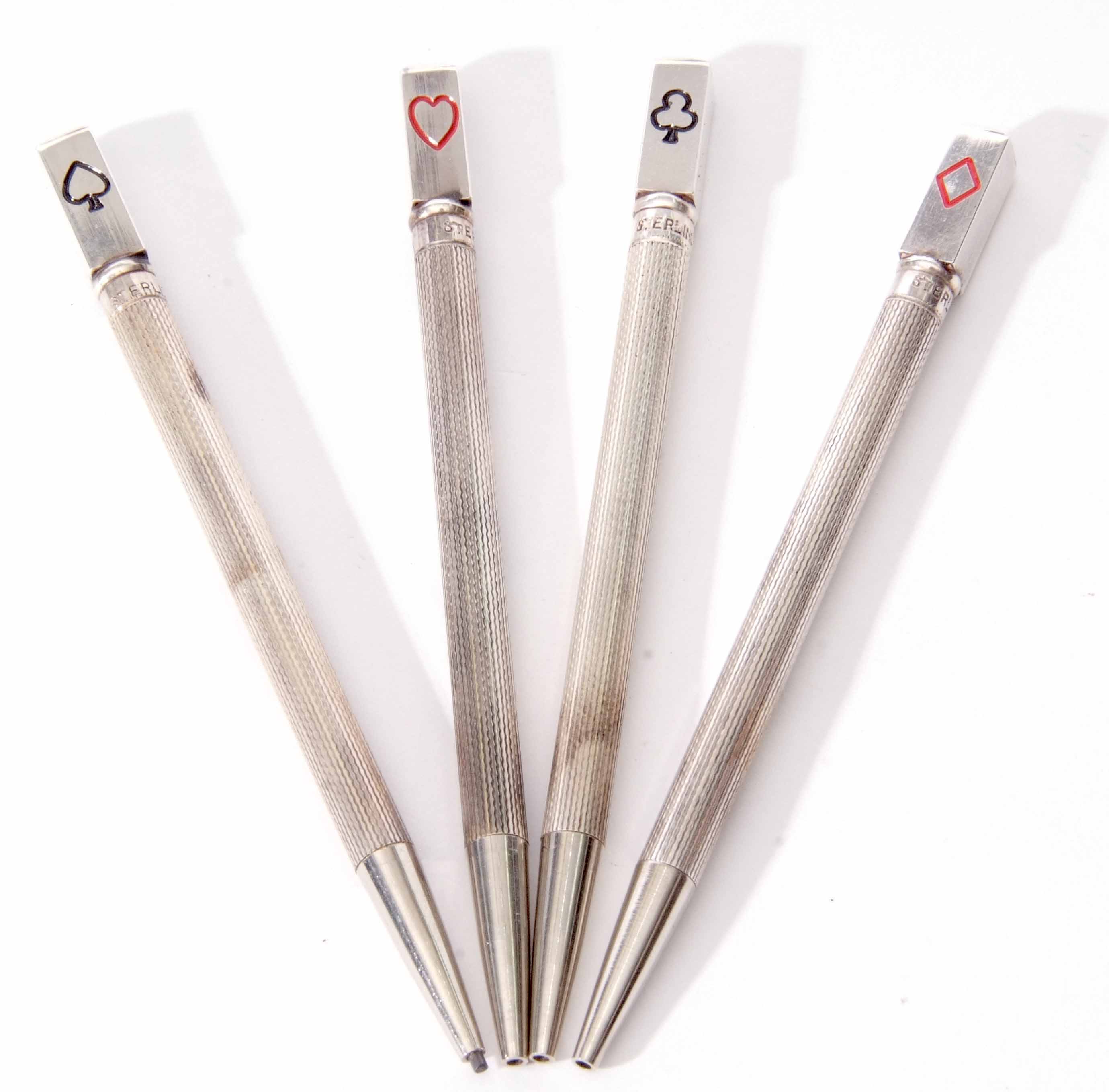 Cased set of four white metal Bridge pencils, each of engine turned cylindrical form and each