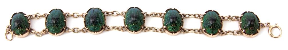 Vintage Egyptian revival scarab beetle bracelet featuring seven iridescent green scarabs