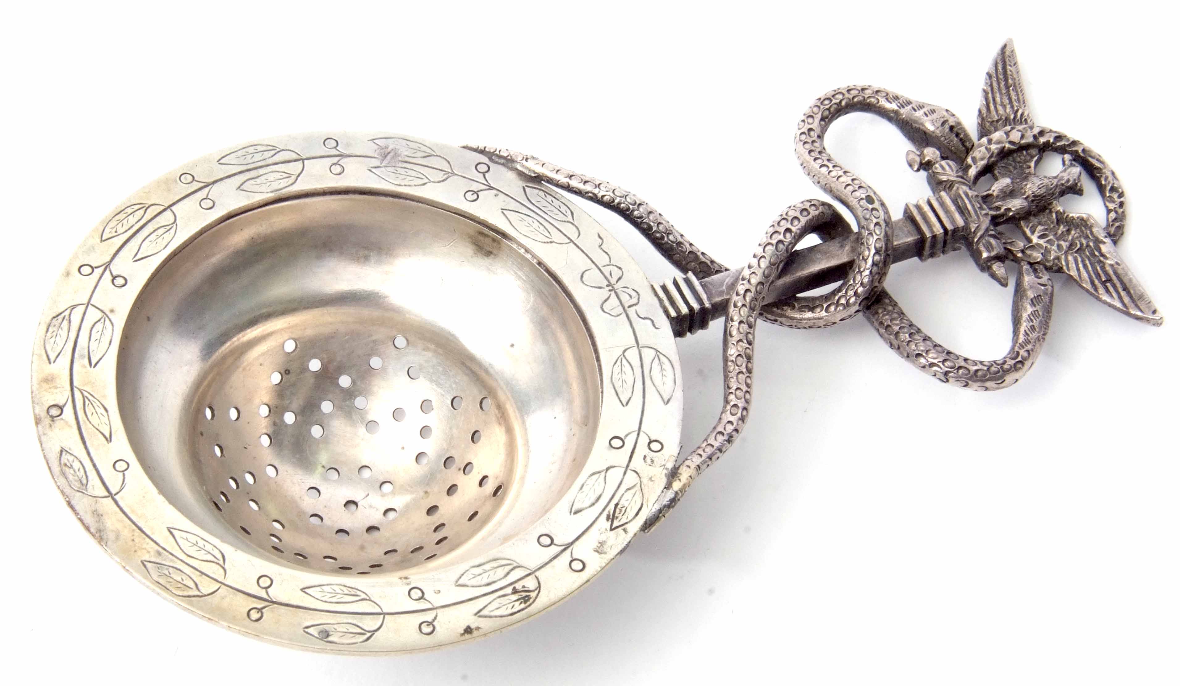Continental tea strainer, the circular pierced bowl with engraved foliate border and handle topped