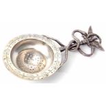 Continental tea strainer, the circular pierced bowl with engraved foliate border and handle topped