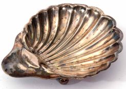 Edward VII shell butter dish of typical scalloped form with polished thumb piece and raised on three
