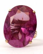 Large oval shaped amethyst dress ring, faceted cut and raised in a four claw basket mount, stamped