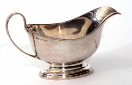 George VI gravy boat of polished form with beaded rim, strap work handle on spreading oval base,