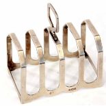 George V four slice toast rack of strapwork form with central carry handle, width 7.4cm, weight