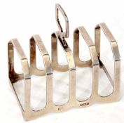 George V four slice toast rack of strapwork form with central carry handle, width 7.4cm, weight