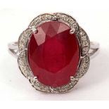 Modern ruby and diamond cluster ring, the oval faceted ruby 12 x 10mm, within a surround of small