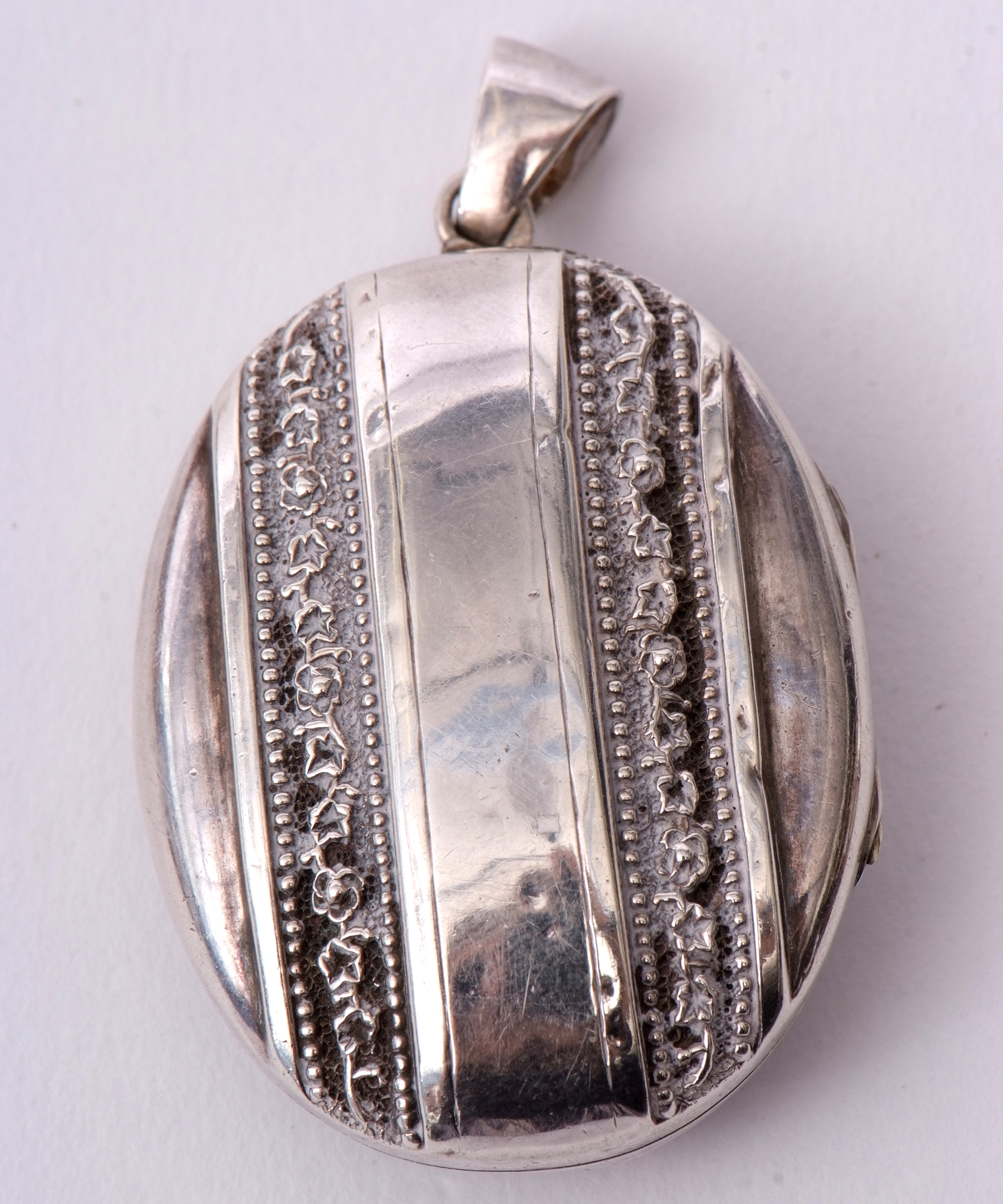 Antique oval plated locket of ribbon design, chased and engraved detail, 4.5 x 3.5cm - Image 2 of 3