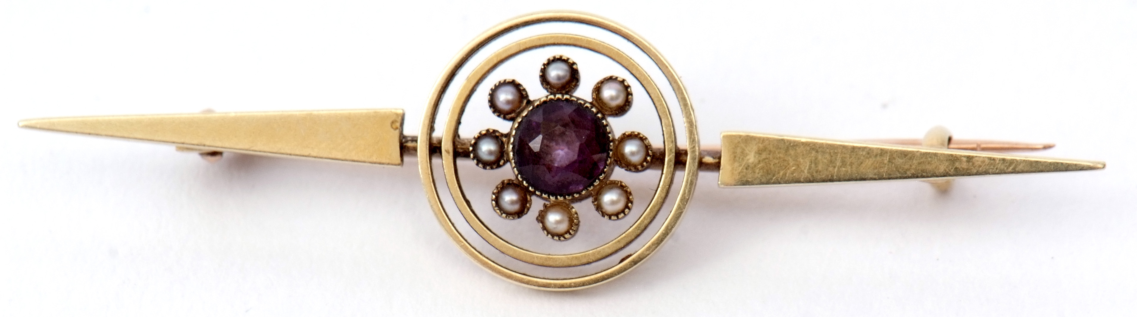 A 15ct amethyst and seed pearl bar brooch, a plain polished open work design with a central bezel