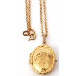 Modern 9ct gold locket and chain, the oval shaped locket with chased engraved foliate design