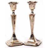 Two George V candlesticks, each with fixed urn shaped sconces to tapering and fluted square