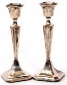 Two George V candlesticks, each with fixed urn shaped sconces to tapering and fluted square