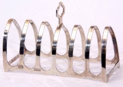 Elizabeth II six-slice toast rack of arched form with central carry handle, width 11cm, weight