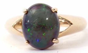 Modern single opal doublet ring, the cabochon four claw set and raised between angular pierced
