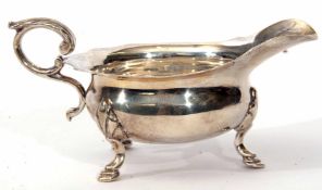 Late Victorian sauce boat of polished form with cut card rim, cast and applied flying c-scroll