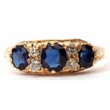 Sapphire and diamond ring featuring three graduated faceted sapphires interspersed by four small
