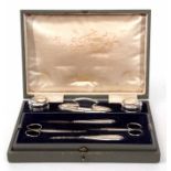 George V cased dressing table set comprising two silver lidded and faceted clear glass rouge pots