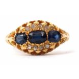 Edwardian 18ct gold sapphire and diamond cluster ring featuring three oval graduated sapphires,