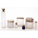 Mixed Lot: comprising four various faceted and cut glass silver lidded toiletry bottles, two of