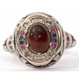 Modern graduation style ring featuring a central cabochon opal doublet raised within a surround of