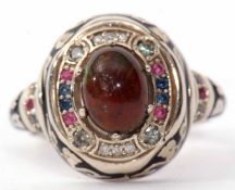 Modern graduation style ring featuring a central cabochon opal doublet raised within a surround of