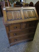 OAK FRAMED OLD CHARM BUREAU WITH LINEN FOLD FRONT FITTED WITH THREE FULL WIDTH DRAWERS AND TURNED