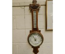 OAK FRAMED ANEROID BAROMETER WITH CARVED DETAIL AND ENAMELLED DIAL