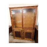 TEAK FRAMED BOOKCASE WITH TWO GLASS SLIDING DOORS TO TOP WITH TWO PANELLED CUPBOARD DOORS TO BASE