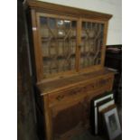 EARLY 19TH CENTURY PITCH PINE BOOKCASE WITH TWO ASTRAGAL GLAZED DOORS OVER TWO DRAWERS AND TWO