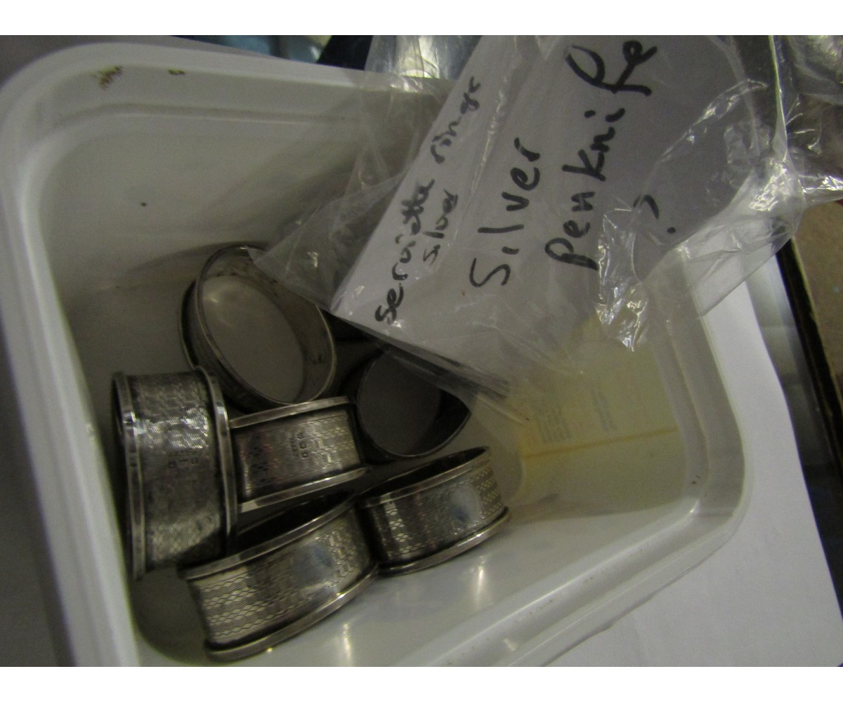 TUB CONTAINING SEVEN SILVER NAPKIN RINGS AND A PENKNIFE