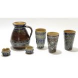 Group of 19th century Doulton stoneware items including a large jug, 3 beakers with typical
