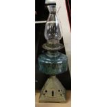 Late 19th century oil lamp with metal shaped foot and green glass reservoir, 50cm high