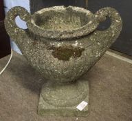 Small weathered composition two-handled pedestal garden urn, 33cm high