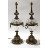 Pair of Regency style brass lamps with glass reservoirs and loop handles, 82cm high