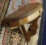 Early 20th century oak console table of demi-lune form with pierced support, 67cm wide