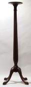 Mahogany torchere stand, circular top on a reeded column terminating in a quadruped base, 137cm