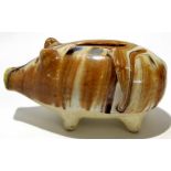 English pottery money box modelled as a pig, decorated with a Whealden type glaze on four stub feet,