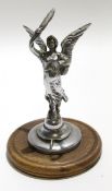 Silver metal car mascot modelled as a winged angel mounted on a circular wooden base