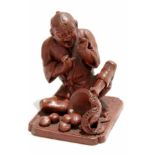 Oriental stained plaster figure of a man on a rectangular base, alarmed by a snake, 7cm high