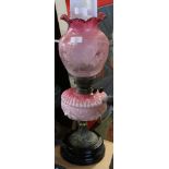 Victorian cranberry coloured oil lamp with shaped font and etched cranberry shade, the shade with