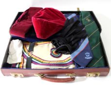 Two cases of Masonic regalia and items of clothing including a Masonic apron and two gilt badges (